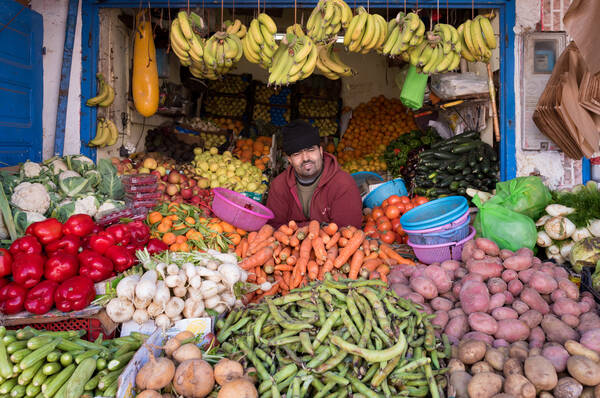 Ein Händler in einem Obst- und Gemüsestand am Markt.
