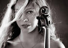 Portrait einer jungen Frau, die die Schnecke einer Violine vor dem Gesicht hält. Schwarz-Weiß.