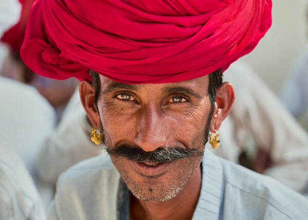 Portrait eines schmalgesichtigen Mannes, Stoppelbart und üppiger Schnauzer mit goldenen Ohrringen und großem roten Turban.