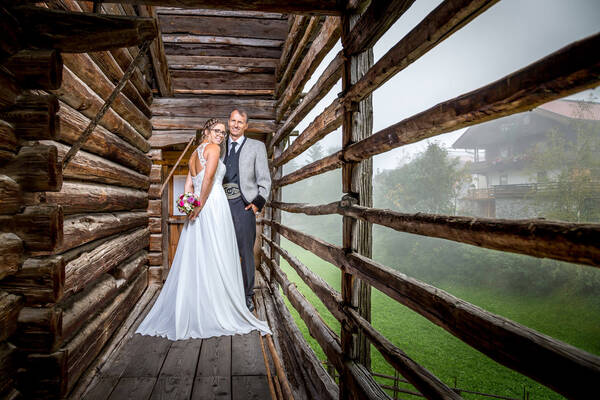 Ein Brautpaar steht auf einem Gang eines Stadels..