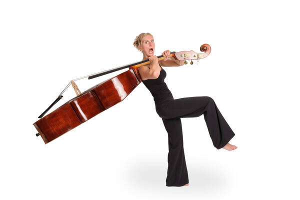 Eine zarte blonde Frau in schwarzem Hosenanzug hat einen Kontrabaß geschultert, der sie fast nach hinten umwirft. Die Frau schaut erschrocken.