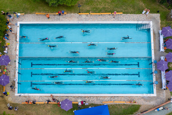 Schwimmbecken mit Triathlon-Athleten beim schwimmen aus der Vogelperspektive.