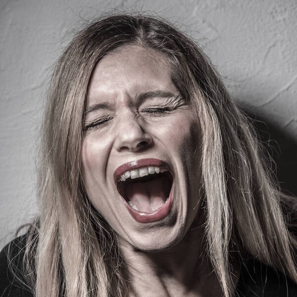 Portrait einer langhaarigen, blonden Frau, die schreit