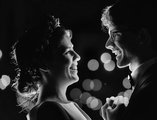 Portrait eines Brautpaares im Profil, Lichter im Hintergund. Schwarz-Weiß.