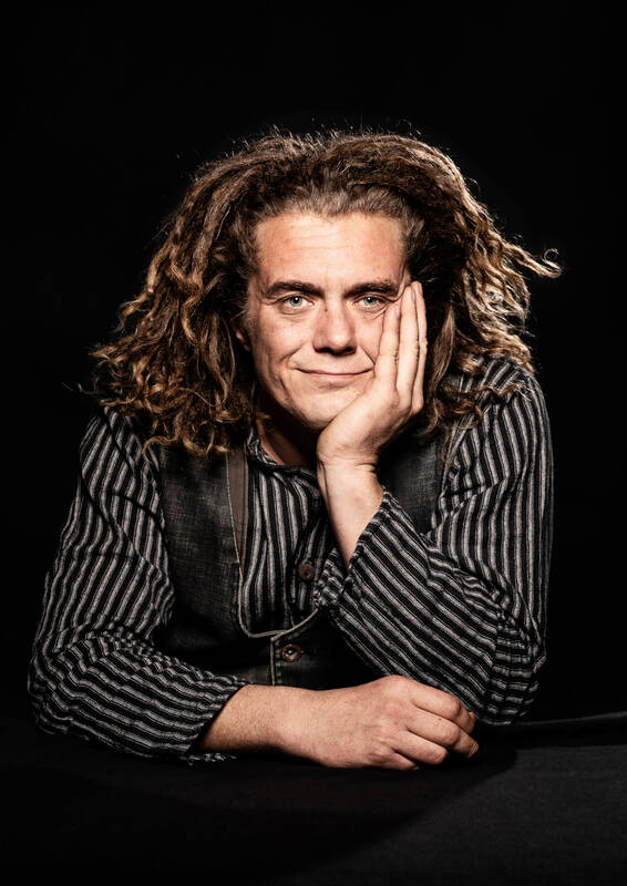 Portrait eines Mannes, der sein Kinn in die Hand stützt.