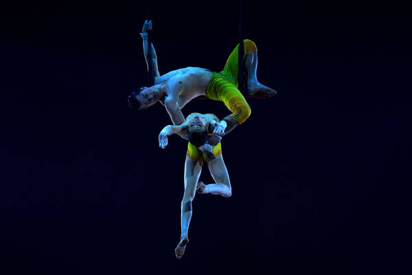 Ein Artistenpaar auf dem Trapez in der Dunkelheit