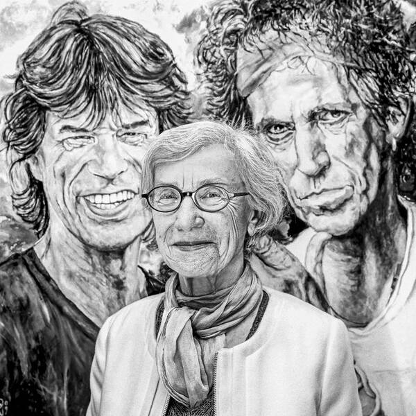 Die österreichische Autorin und Philosophin Hedwig Wingler-Tax vor einem Gemälde mit den Rolling Stones Musikern Mick Jagger und Keith Richards. Schwarz-Weiß.