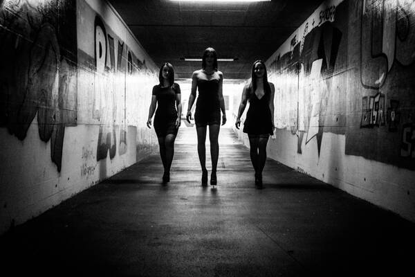 Drei Frauen in einer Unterführung mit Graffity im Gegenlicht. Schwarz-Weiß.