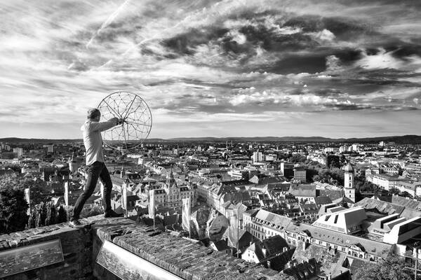 Der Sound-Techniker Dr. Harald Graf-Müller steht mit einem Geräusch-Collector auf dem Schlossberg in Graz. Schwarz-Weiß.