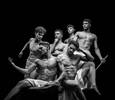 Eine Gruppe junger Männer ist Fotografiert wie eine griechische Skulptur. Die Männer sind muskulös und nur mit einem Lendentuch bekleidet. Schwarz-Weiß.