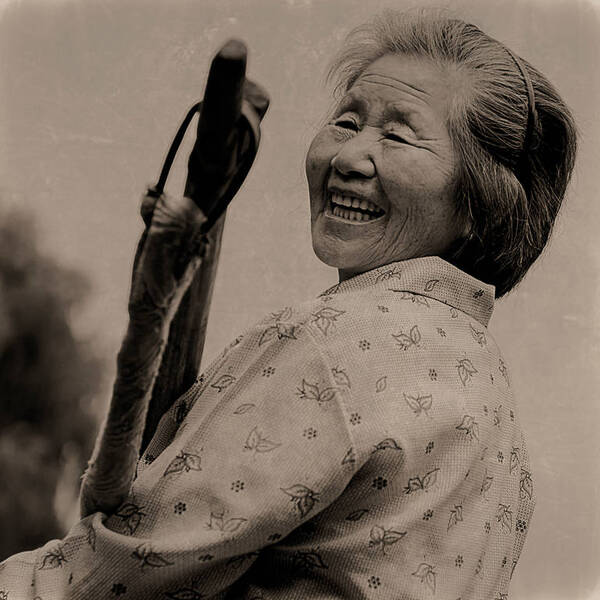 Portrait einer lachenden, alten asiatischen Frau. Schwarz-Weiß, sepia-getönt
