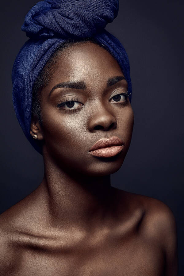Portrait einer Dunkelhäutigen Frau mit blauem Kopftuch