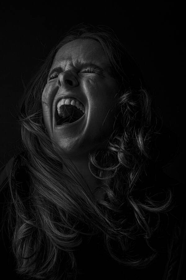 Low Key Portrait einer schreienden Frau. Schwarz-Weiß.