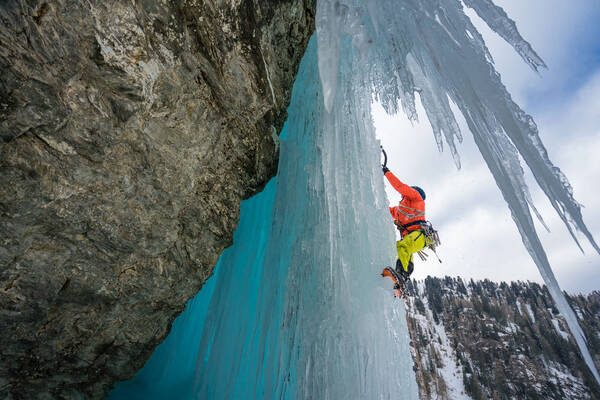 Ein Eis-Kletterer afu einem gefrorenen Wasserfall.