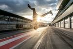 Junger Mann macht einen Salto in der Grand-Prix-Box im Gegenlicht