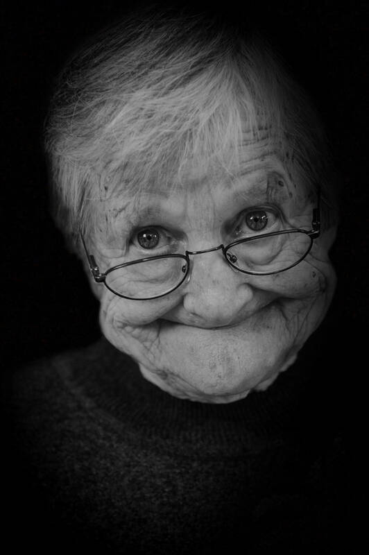Closeup Portrait einer älteren Frau mit Brille und lustigem Gesichtsausdruck. Schwarz-Weiß.