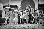 Kinder mit aufblasbaren Instrumenten spielen bei einem Familienfest. Schwarz-Weiß.