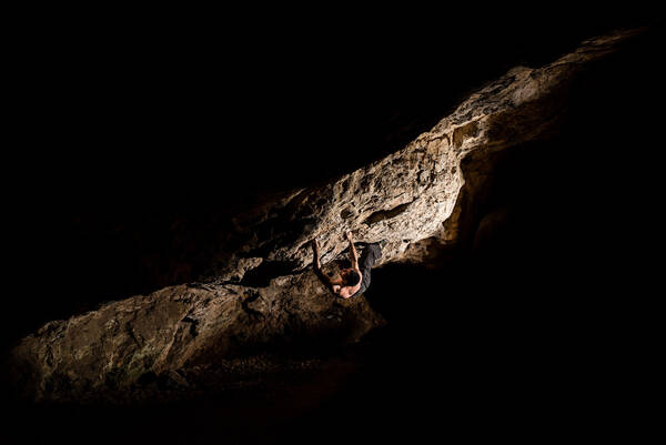 Kletterer an einer Felswand im Dunkeln.