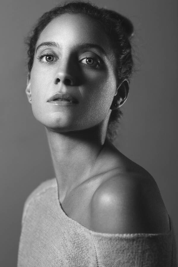 Portrait einer jungen Frau, das Oberteil leicht über die Schulter gerutscht. Schwarz-Weiß.