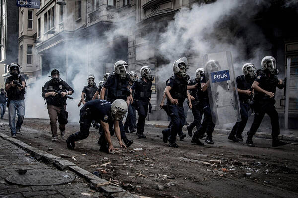 Polizei geht in Schutzausrüstung mit Nebelgranaten gegen Protestierende vor.