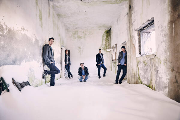 Fünf junge Männer sind in einem alten, verschneiten Raum.