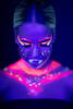Portait einer jungen Frau, die mit fluoreszierendem MakeUp geschminkt ist.