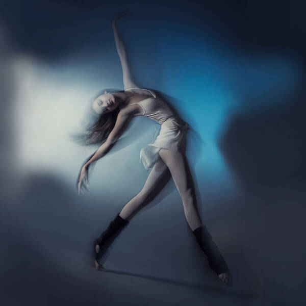 Eine Tänzerin in blauem Licht. Bewegungsunschärfe.
