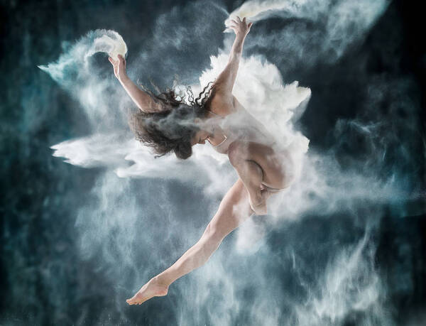Tänzerin in dynamischer Sprungbewegung mit weißen Staubschwaden.
