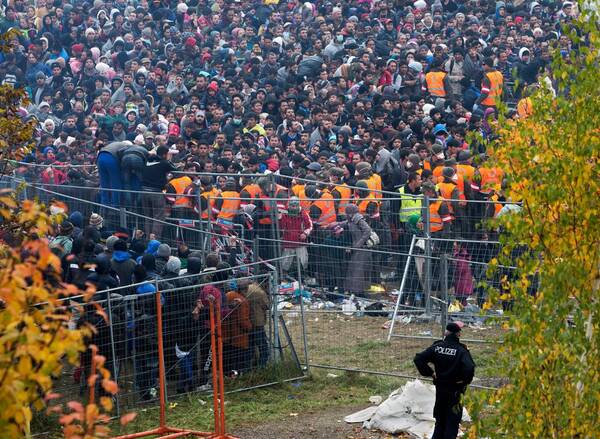 Grenzuebergang Spielfeld am 28.10.2015. Menschen hinter Absperrgittern an der Grenze.