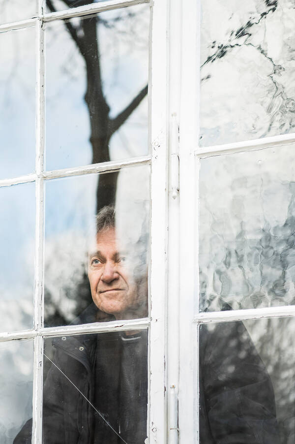 Portrait des österreichischen Schauspielers Wolfram Berger durch ein Fenster. Spiegelungen.