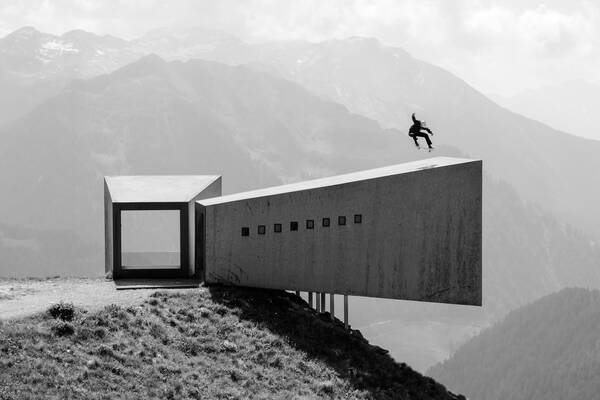 Ein Skateboarder macht einen Sprung auf einem Teil des Passmuseums Timmelsjoch. Schwarz-Weiß