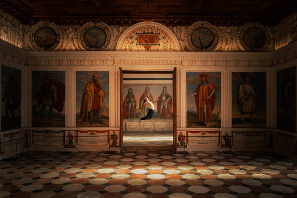 Der spanische Saal im Schloss Ambras in Tirol. Durch eine geöffnete Türe sieht man im Nebenraum einen Tänzer im Sprung.