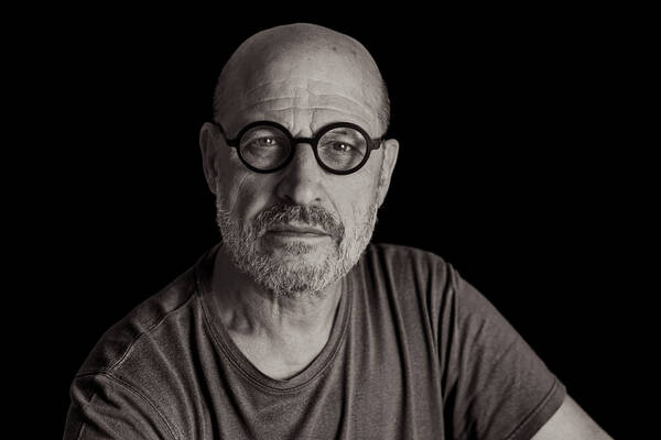 Portrait eines Mannes mit runder, schwarzer Brille. Schwarz-Weiß