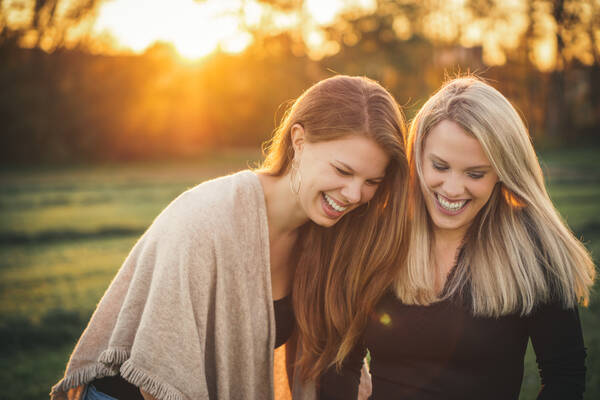 Frauen lachend im Abendlicht.