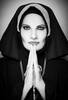 Portrait eines Models als Nonne im Habit, Hände mit Rosenkranz gefaltet. Schwarz-Weiß.