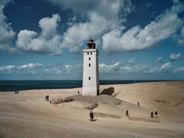 Der Leuchtturm von Rubjerg Knude Fyr, Dänemark, mit Spaziergängern.