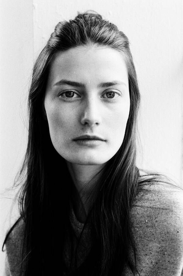 Portait einer jungen Frau mit langen, dunklen Haaren. Schwarz-Weiß.