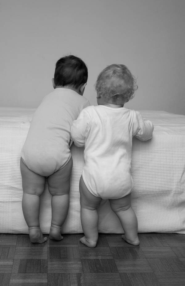 Zwei Kleinkinder von hinten. Schwarz-Weiß.