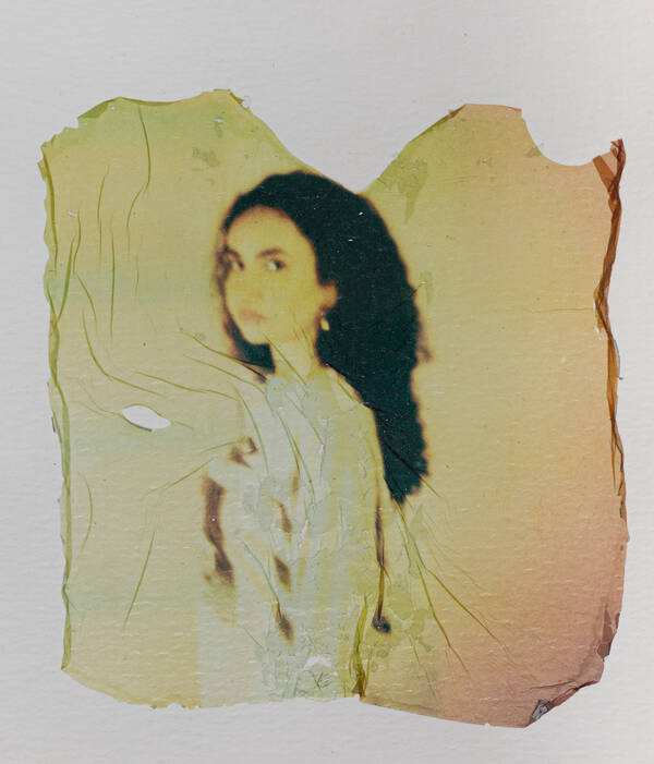 Abgelöste Emulsion eines Polaroid-Bildes mit einem Portrait eines Mädchens.