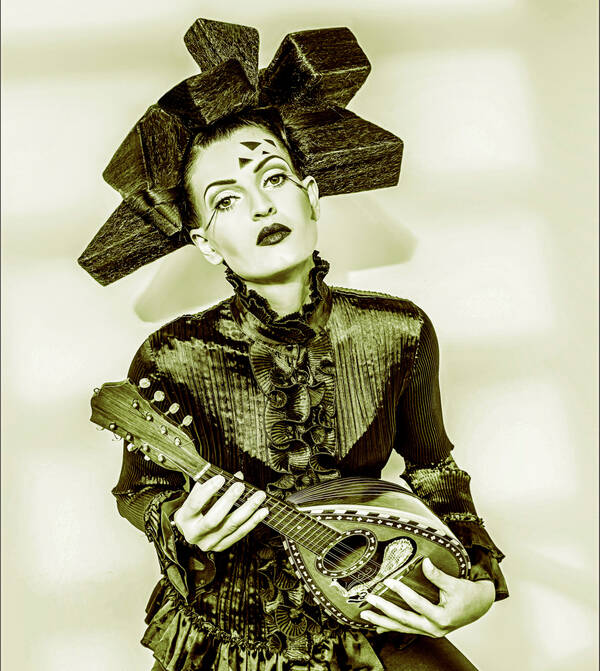 Eine auffällig geschminkte Frau mit kubistischer Frisur spielt Mandoline. Duo-Tone.