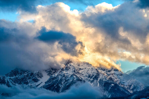 Imposante Wolken- und Lichtstimmung im verschneiten Gebirge.