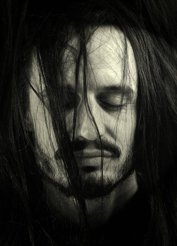 Portrait eines bärtigen Mannes mit geschlossenen Augen, dem einige Strähnen des langen Haares über das Gesicht hängen. Schwarz-Weiß.