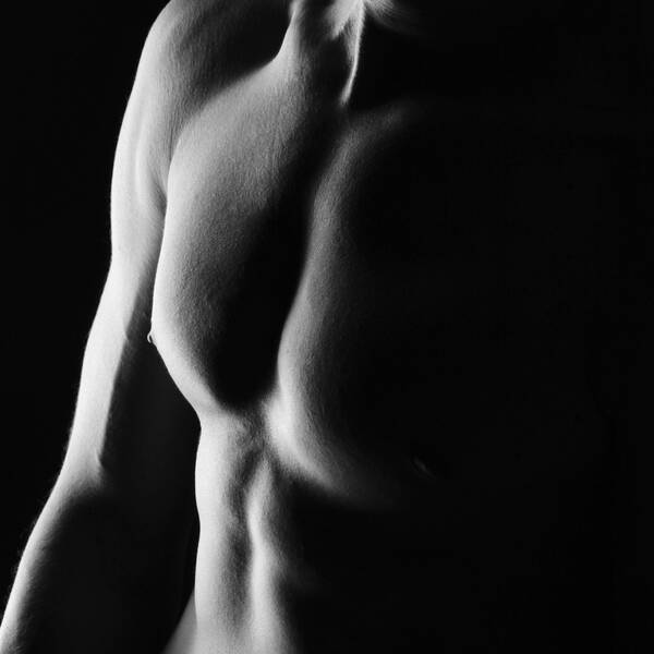 Low Key Aufnahme einer muskulösen Männerbrust. Schwarz-Weiß.