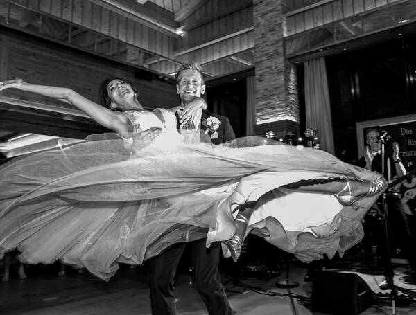 Brautpaar beim Tanz: der Bräutigam wirbelt die Braut durch die Luft. Schwarz-Weiß.